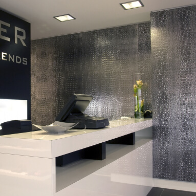 A modern office with an elegant reception area and a striking wall panel with a crocodile skin texture.