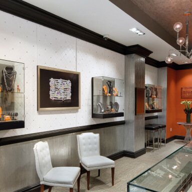 A modern jewelry store with a 3D textured wall, showcasing a variety of jewelry in glass cases, and a comfortable seating area for customers.