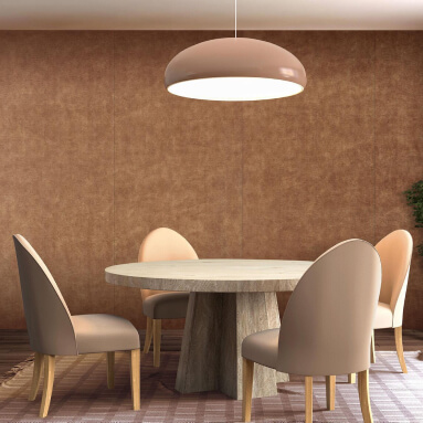 Comedor con una mesa redonda de madera y cuatro sillas suaves en diferentes tonos de beige, una gran lámpara colgante del techo y una pared de cuero marrón texturizada detrás de la mesa.