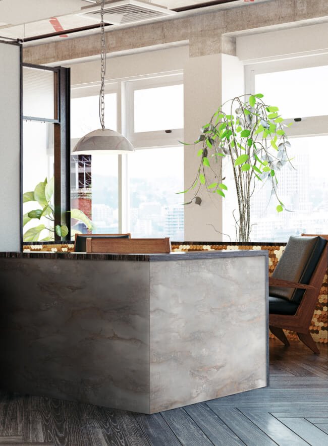 Interior de oficina tipo loft con énfasis en materiales naturales: un panel de pared de piedra, suelo de madera y plantas vivas. Un sofá y un sillón de cuero crean un ambiente acogedor para trabajar y relajarse.