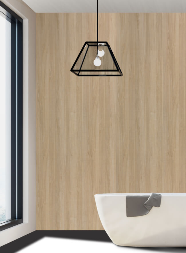 Baño moderno y luminoso con una pared de acento revestida de paneles de madera. Los paneles imitan la textura de la madera natural, creando un ambiente cálido y acogedor. Sobre el fondo de los paneles, una bañera ovalada blanca destaca en contraste. Los accesorios de baño negros y un motivo geométrico en la pared adyacente aportan dinamismo y estilo.