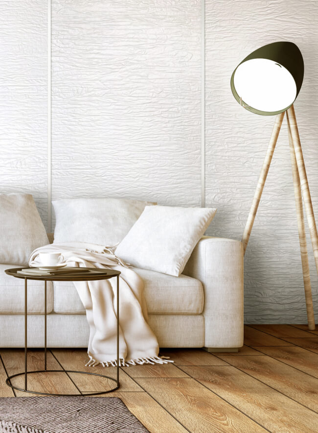 Soggiorno moderno con divano bianco, lampada da terra e piccolo tavolino.