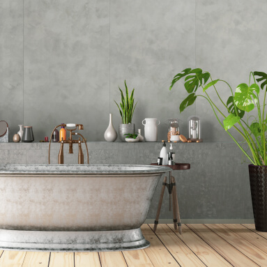 Vintage Wandpaneel in Steinoptik in einem modernen Badezimmerdesign. Die strukturierte graue Wand bildet einen Kontrast zum Holzboden und den kupferfarbenen Armaturen. Eine weiße Badewanne auf Füßen und grüne Pflanzen schaffen eine gemütliche Spa-Atmosphäre.
