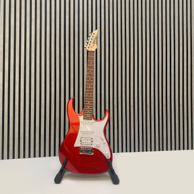 WallFace Akustikpaneele mit grauer Lamellenstruktur als Hintergrund mit roter E-Gitarre